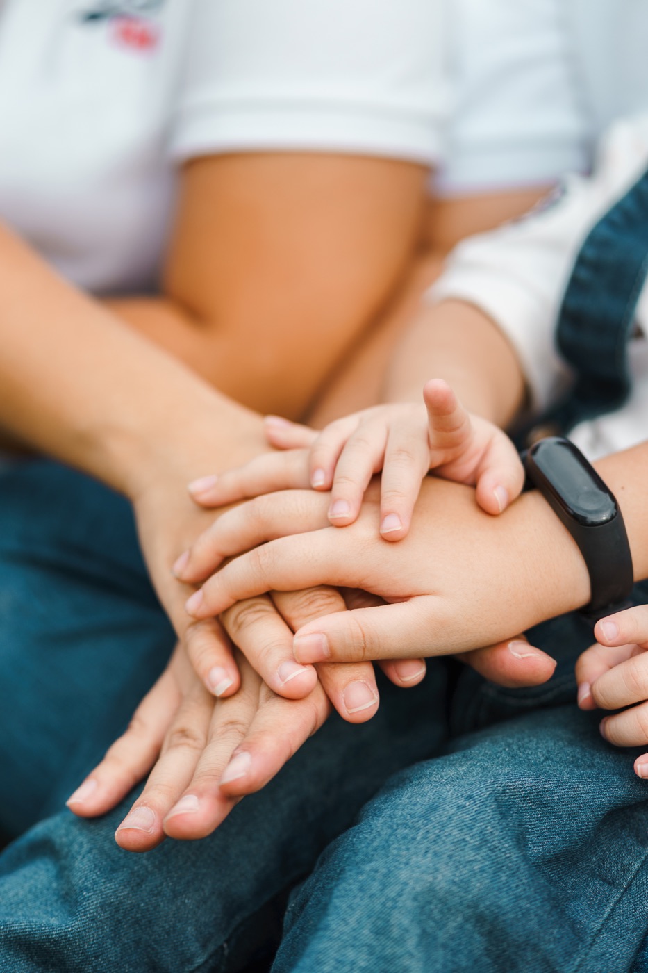 Hände von Erwachsenen und einem Kind übereinander